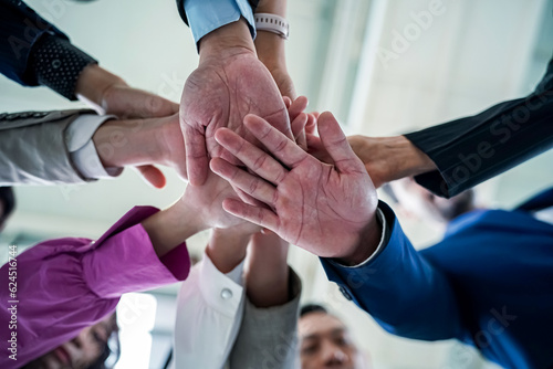 Business team stacking hands as symbol of unity