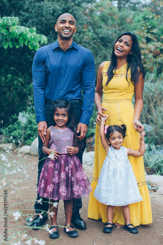 beautiful indian family standing and smiling in the park with trees and greenery © kristineldridge