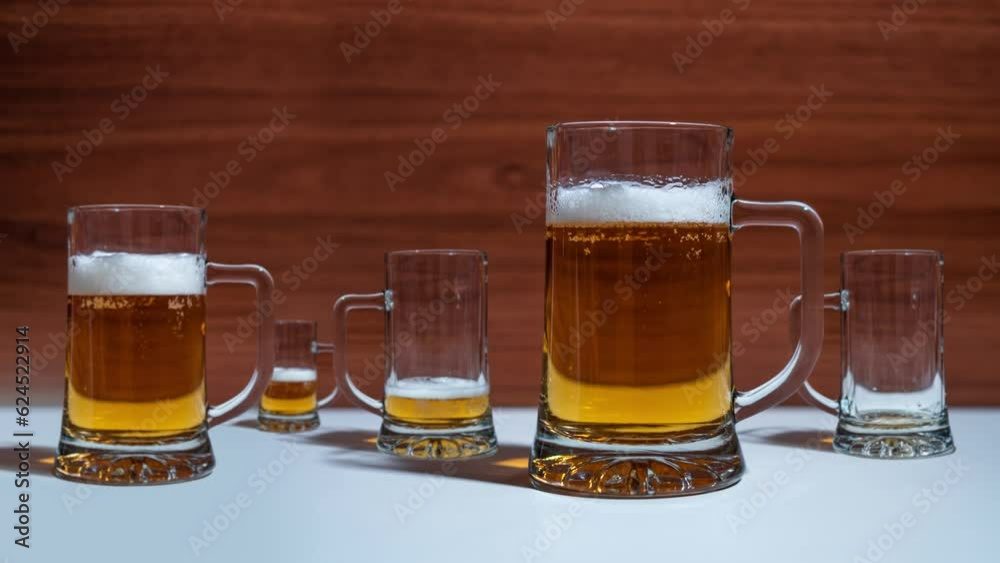 Glasses on the table fill up with beer in stop motion Glasses on the table fill up with beer in stop motion