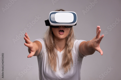 Amazed young woman in virtual reality, using vr glasses headset