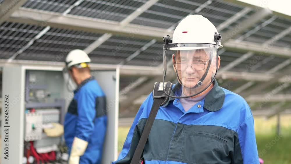 Mature Service Engineer man standing in front of solar panels. Technician maintenance solar cells on Solar Energy Plant under morning sunlight. Technology solar energy renewable Mature Service Engineer man standing in front of solar panels. Technician maintenance solar cells on Solar Energy Plant under morning sunlight. Technology solar energy renewable