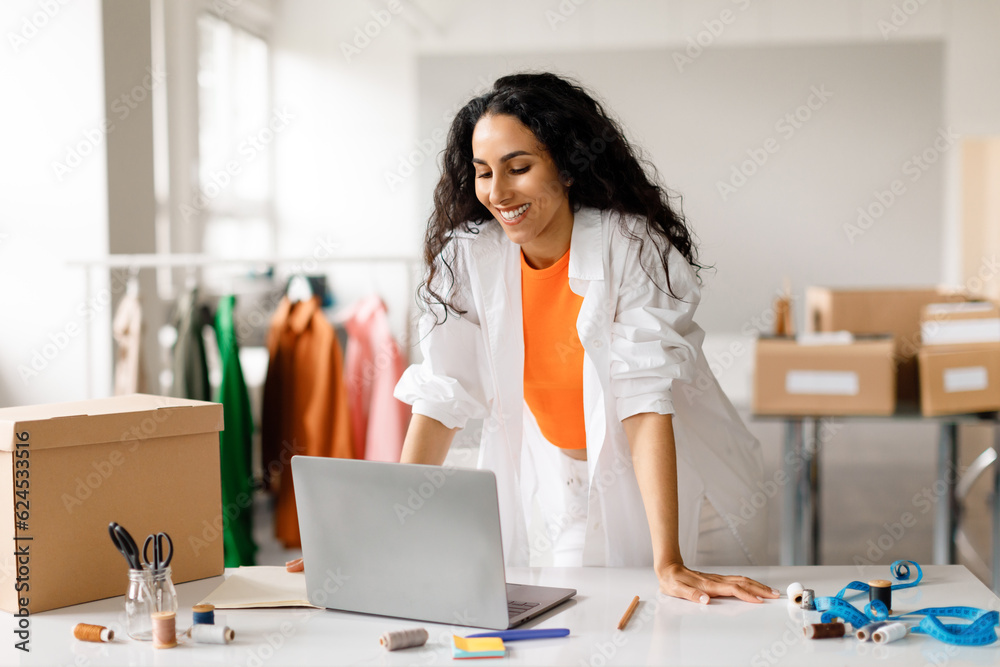 Lady Looking At Laptop Receiving Online Orders At Clothes Store Lady Looking At Laptop Receiving Online Orders At Clothes Store