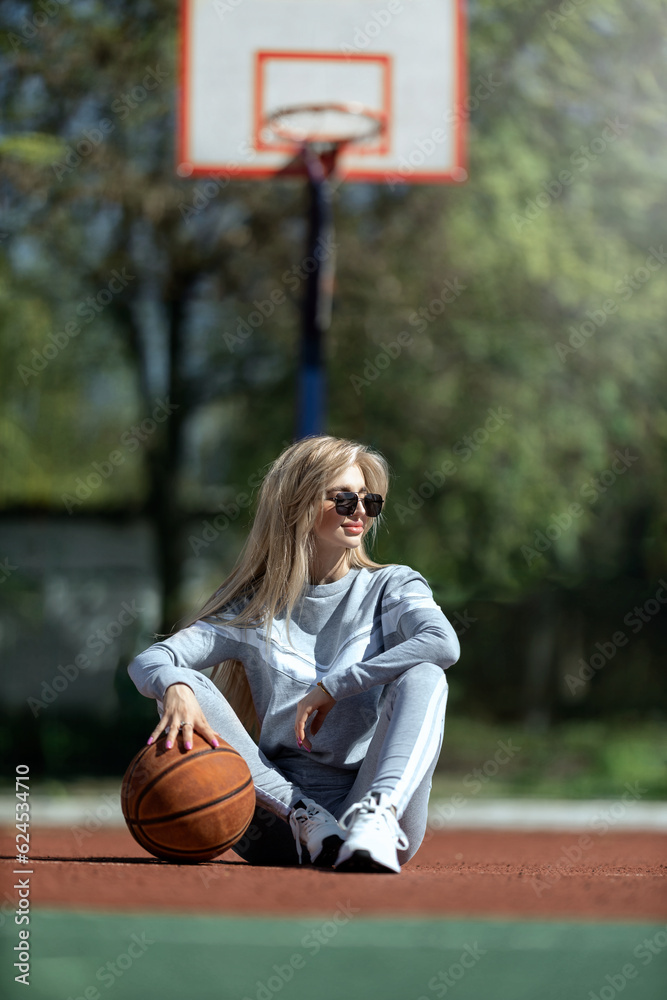 sports girl blonde sits on the basketball court sports girl blonde sits on the basketball court