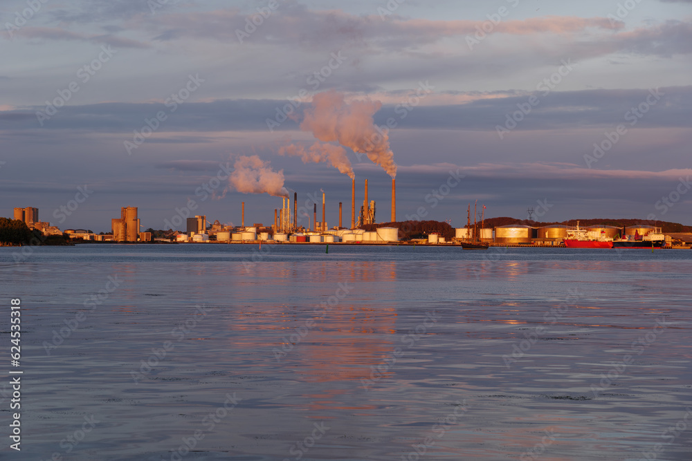 Outdoor landscape scenery during twilight on the waterfront with background of vessel ship and industrial buildings in Aalborg, Denmark.