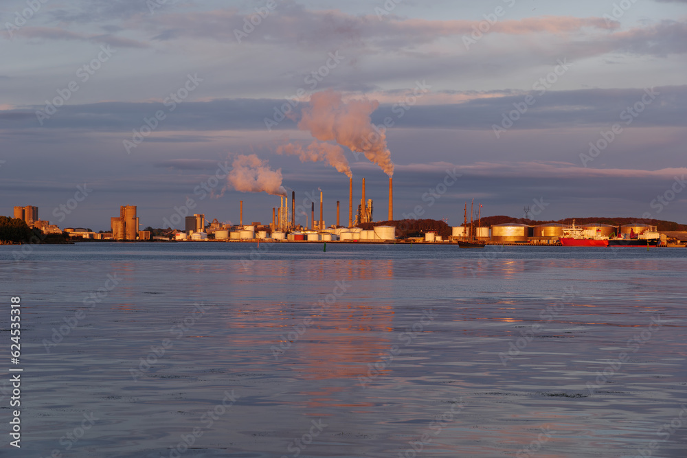 Fototapeta premium Outdoor landscape scenery during twilight on the waterfront with background of vessel ship and industrial buildings in Aalborg, Denmark.