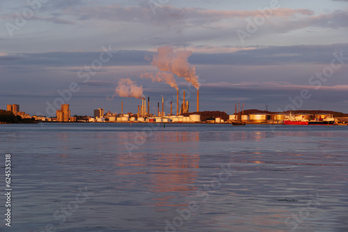 Outdoor landscape scenery during twilight on the waterfront with background of vessel ship and industrial buildings in Aalborg, Denmark.