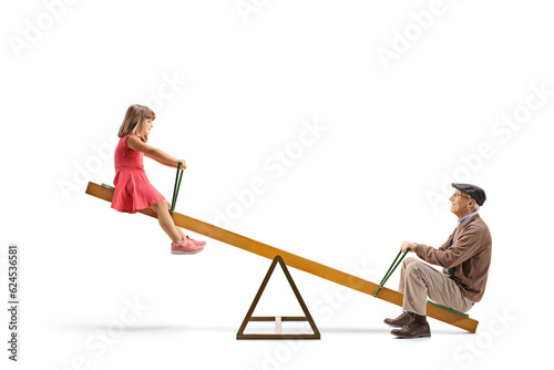 Grandfather playing on a seesaw with a little girl photo