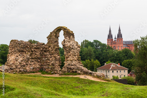 Summer rural environmental landscape. Ruins of the Rezekne Castle Hill with dramatic sky. Tourists look at urban ruins. Rezekne, Latvia photo