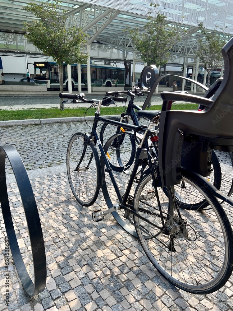 Obraz premium Bike for kids parked in a bike rack across the street. ecological mode of transport