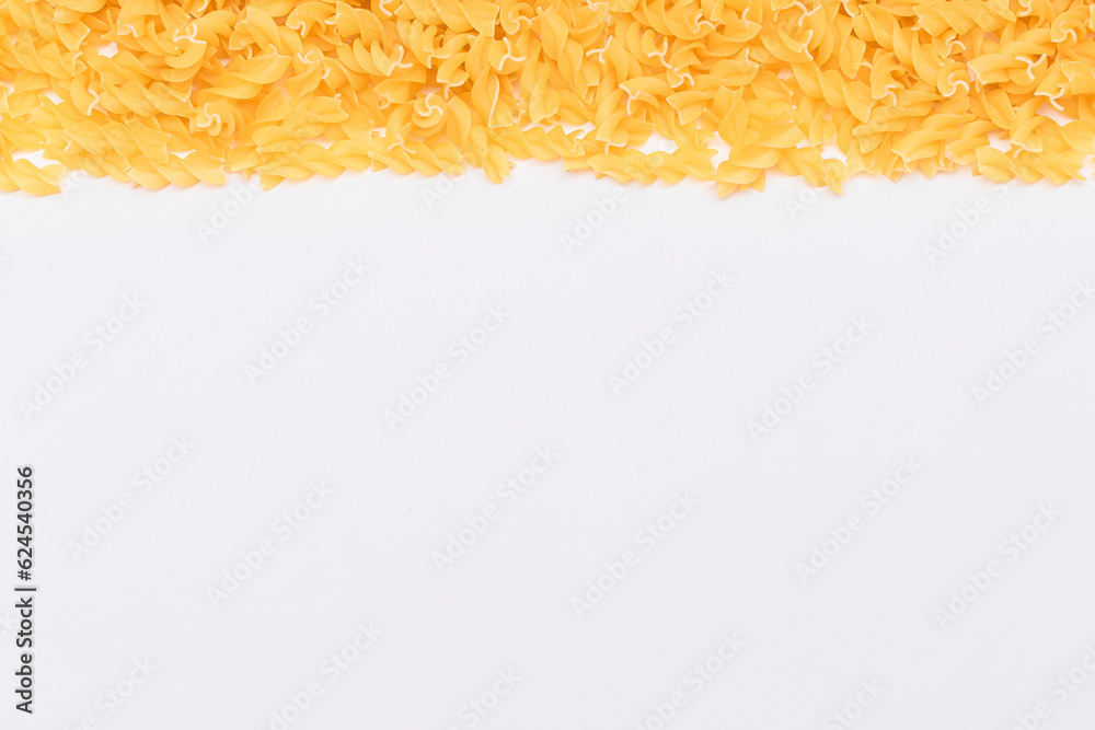 Obraz premium Uncooked Fusilli Pasta with Copy Space on White Background. Raw and Dry Macaroni. Fat and Unhealthy Food - Flat Lay