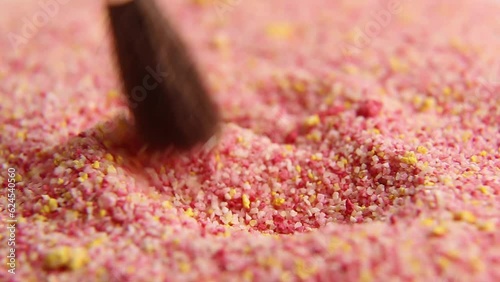 The colored granules are slowly stirred with a brush. asm video. Relaxing video. photo