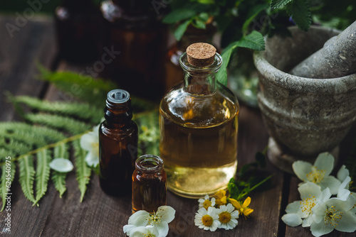 Assortment of pure organic natural essential aroma oil with mint , camomile on wooden background. Concept of herbal, floral ingredients in cosmetology. Alternative medicine, therapy, Ayurveda