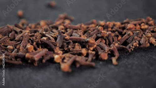 Spices dried cloves on a black background close-up for cooking. The kidneys contain the amount of essential oil which includes eugenol, acetylievgenol, as well as tannins, organic acids oleanolic acid photo