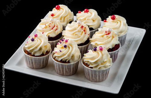 Cupcakes with whipped cream in a white plate.