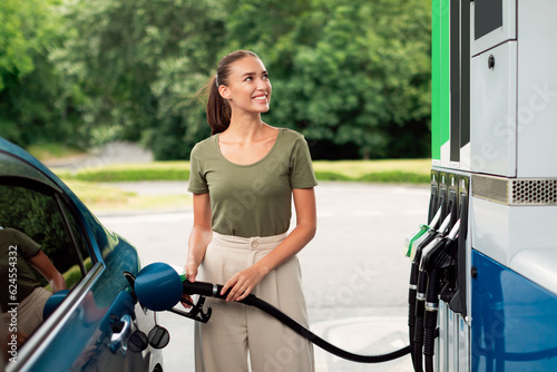 Foto Happy Young Woman Refueling Car At Modern Gas Station Outdoor