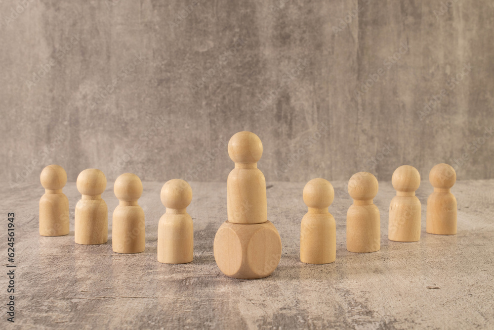 Leadership concept, wooden business team with one person standing out from the crowd on podium. Leadership concept, wooden business team with one person standing out from the crowd on podium.