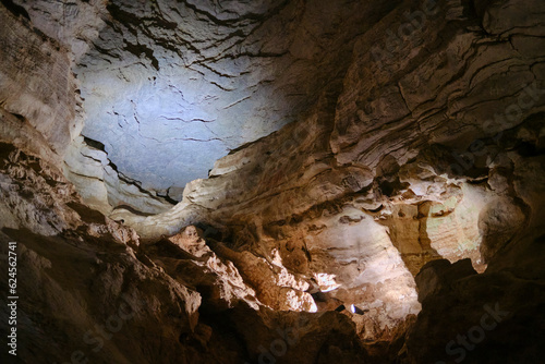 BURNET, TEXASUSA - JULY 3rd 2023: a family with a teenage girl on a road trip during school summer holidays, visiting Longhorn Cavern State Park with its intricate paths and natural stone works.