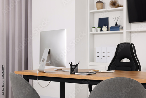 Stylish director's workspace with computer and stationery on desk in office. Interior design © New Africa