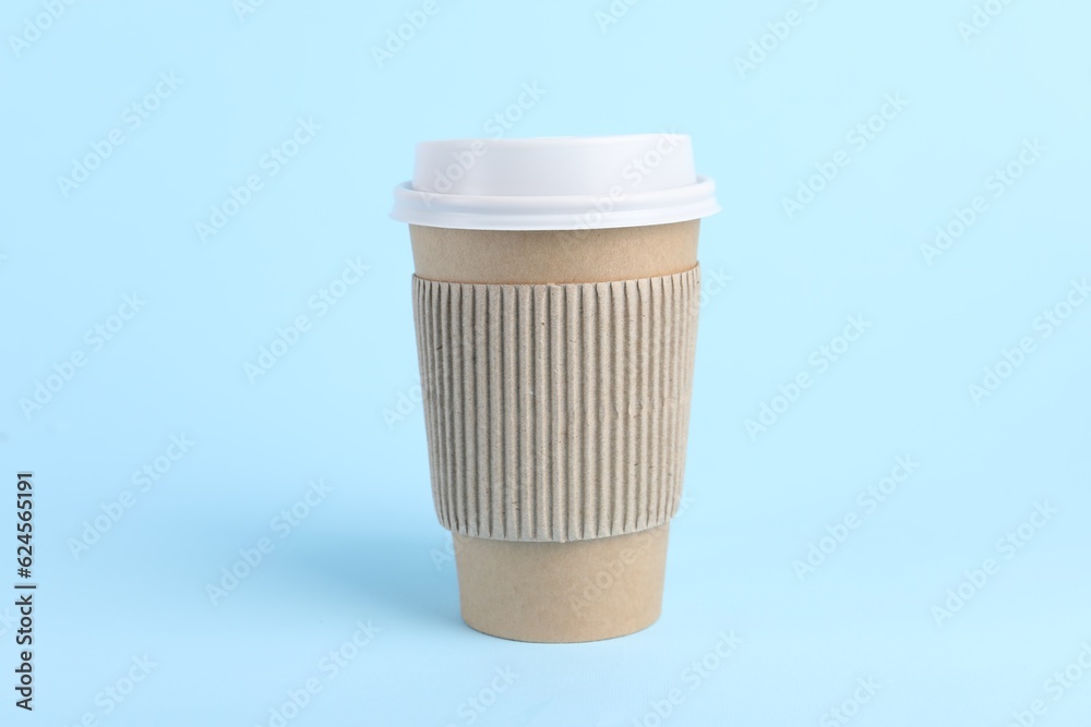 Paper cup with plastic lid on light blue background. Coffee to go