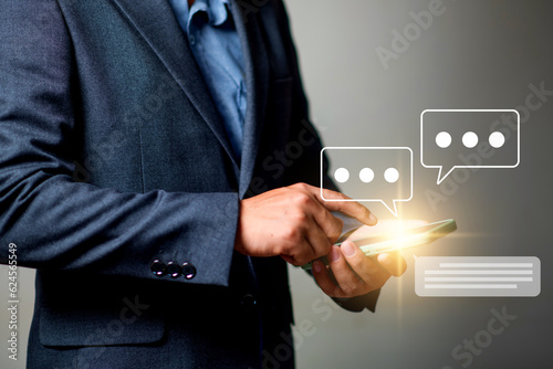 livechat concept, businessman hand using smartphone chatting conversation with chat box icons. Social media maketing concept. photo