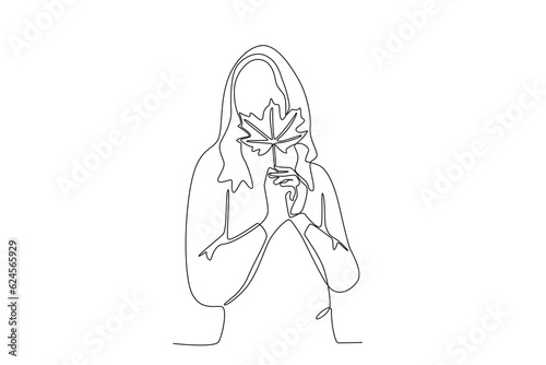 A woman holding autumn leaves. Autumn one-line drawing