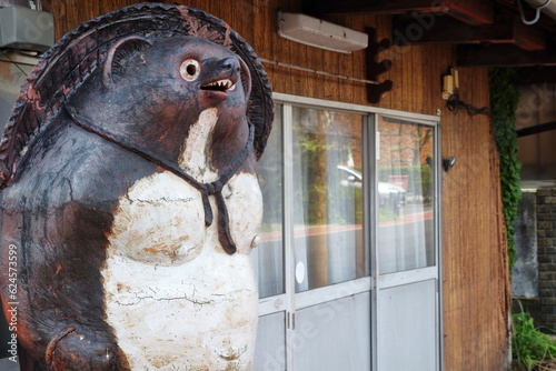 軒下に立つ大きな狸の焼物 photo