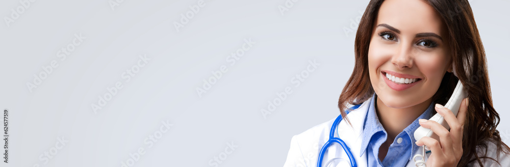 Happy smiling female doctor on phone, isolated over grey color background. Medical call center concept picture. Happy smiling female doctor on phone, isolated over grey color background. Medical call center concept picture.