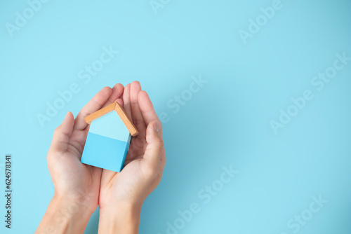 Property, house insurance protection concept. wood model house in hands. house care.