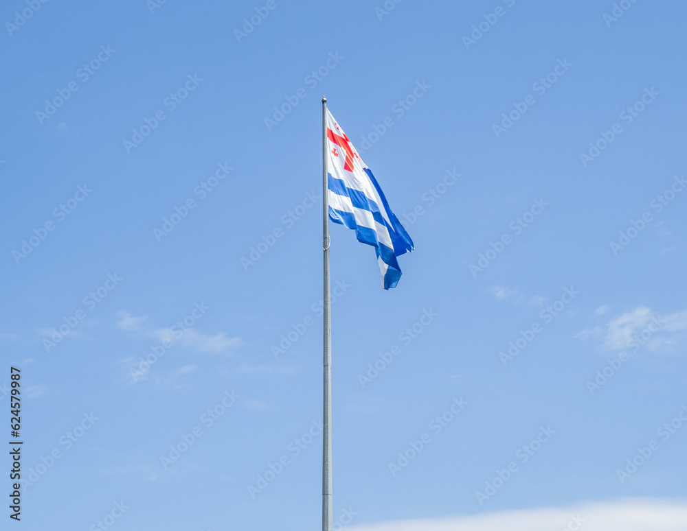 Adjara flag against the sky. Flag of the region in Georgia. State symbols.