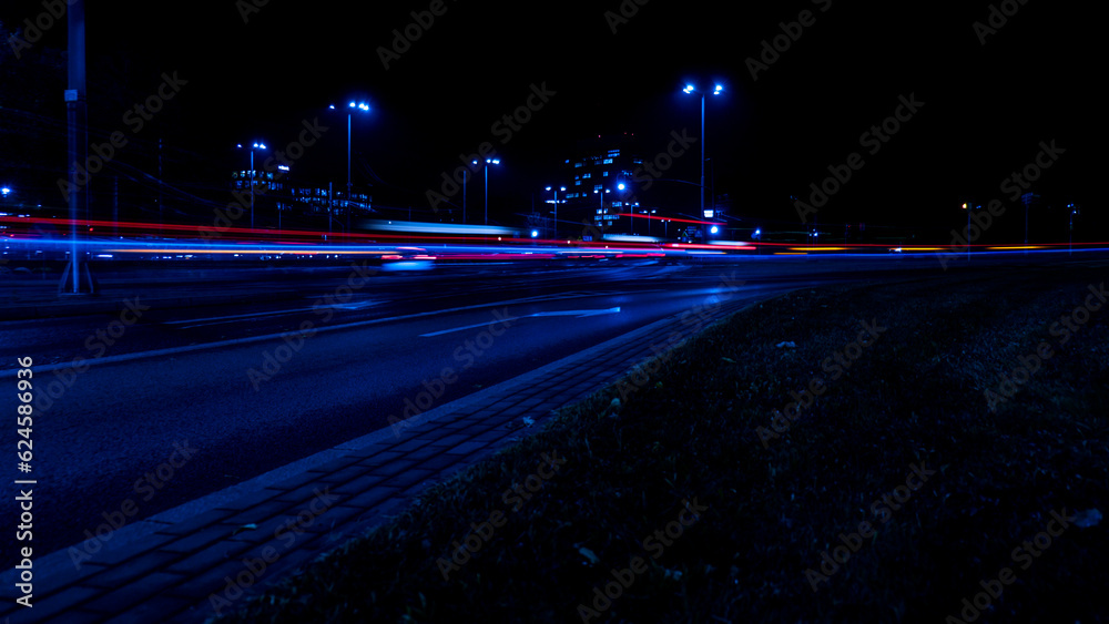 Lights of cars at night. Street line lights. Night highway city. Long exposure photograph night road. Colored bands of red light trails on the road. Background wallpaper defocused photo. 