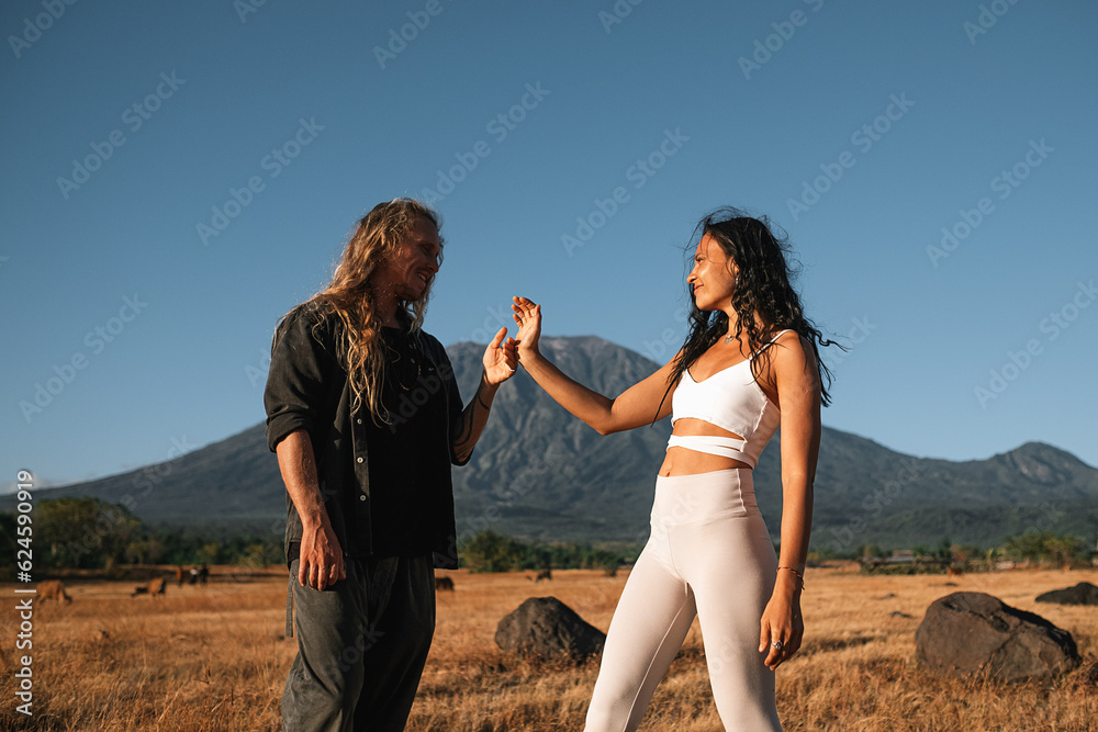 Carefree Couple Enjoying Nature in an Open Field with a Mountain Backdrop. Carefree Couple Enjoying Nature in an Open Field with a Mountain Backdrop.