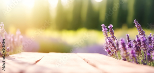 Empty wooden tabletop against the backdrop of blooming lavender fields, summer lavender fields out of focus.