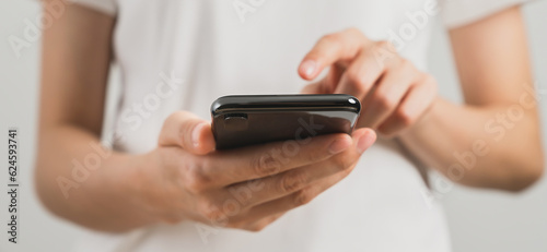 Hand holding smartphone on white background.