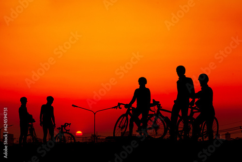 Young people riding bicycles watching the sunset