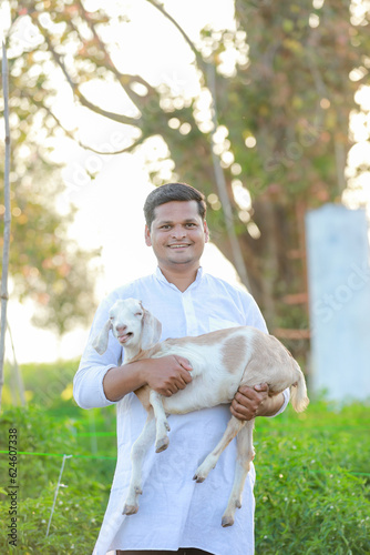 Happy Indian farmer, holding indian Goat photo