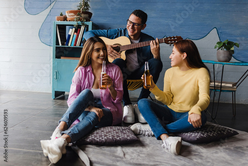 young latin friends having party and playing guitar at home in Mexico Latin America, hispanic people friendship
