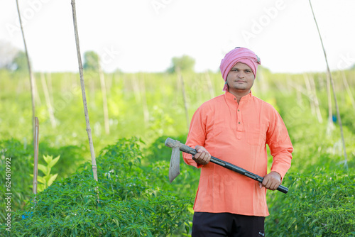 Happy Indian farmer, holding farming tools in hand © SDV Ads
