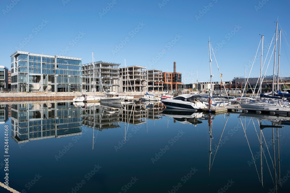 Sailboats and buildings reflected in the smooth waters of inner harbour in Tallinn, Estonia. buildings under construction