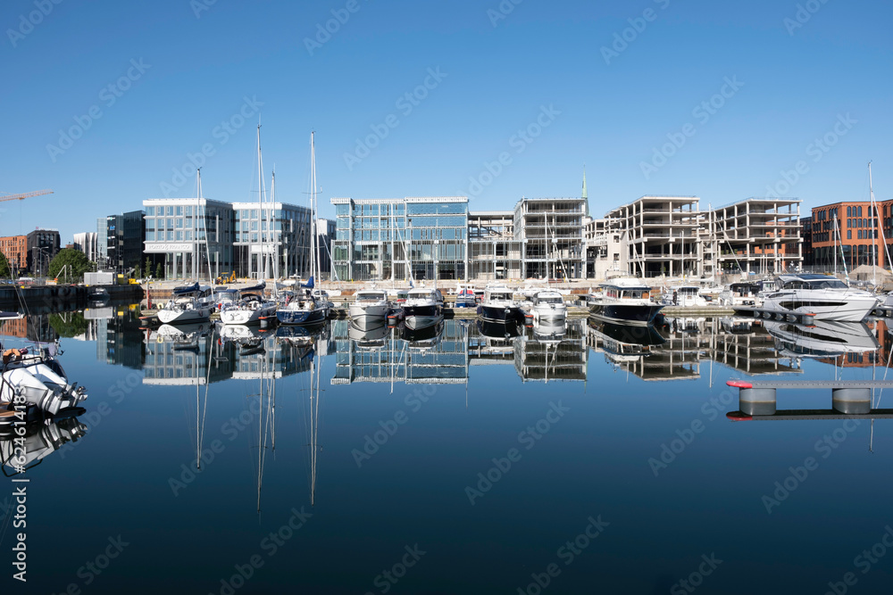 Sailboats and buildings reflected in the smooth waters of inner harbour in Tallinn, Estonia. buildings under construction
