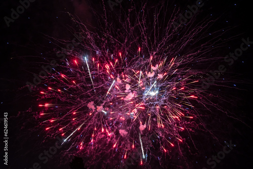 Holiday fireworks explode in the night sky. Selective focus.