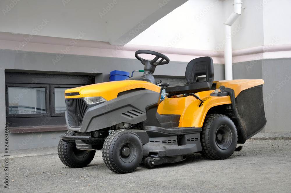 Professional garden tractor under a canopy in the summer heat. Lawn mower. Professional garden tractor under a canopy in the summer heat. Lawn mower.
