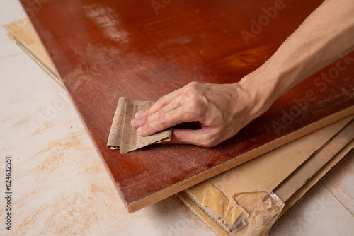 Fotografia Strip paint from wooden table by using sandpaper