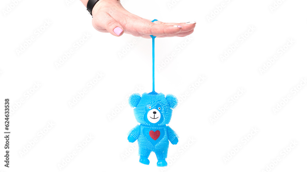 Woman hand holding rubber bear toy isolated on white background. Woman hand holding rubber bear toy isolated on white background.