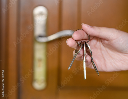 Trzymać pęk kluczy do domu w dłoniach na tle drzwi