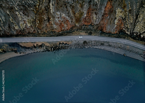 Blue lake with rocky cliff from drone
