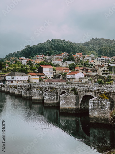 medieval stone bridge with village on background on Canimo de Santiago photo