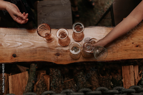 Overhead shot of two restaurant staff grabbing glasses from a slab bar