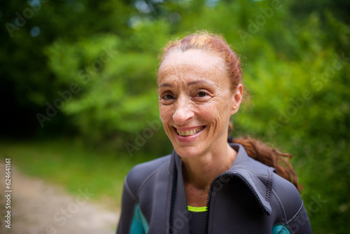 Portrait of a smiling red-haired woman in a wetsuit