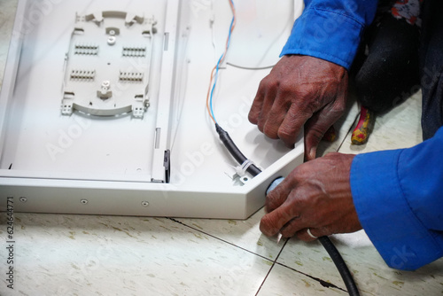 hands installing fiber cable Optical in junction box