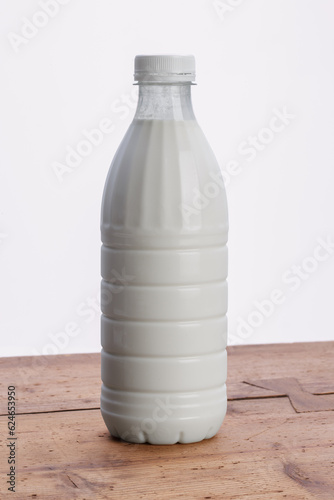 plastic bottle filled with milk on wooden rustic table photo